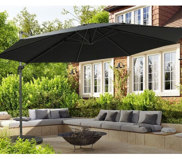 De luxe hangende parasol XXL staat uitgeklapt in de tuin en werpt schaduw over een loungeset. 