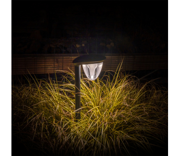Een van de Juno Tuinlampen geeft licht in een donkere tuin. 